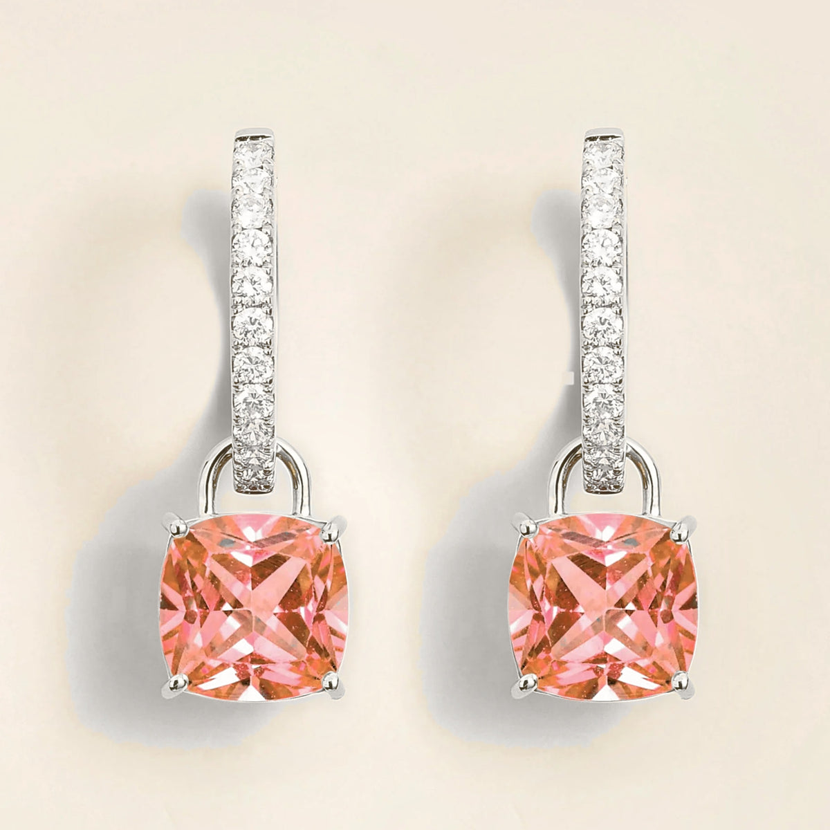 A pair of Roue drop earrings in white gold, featuring cushion-cut Padparadscha sapphires with smaller diamonds around the hoop.