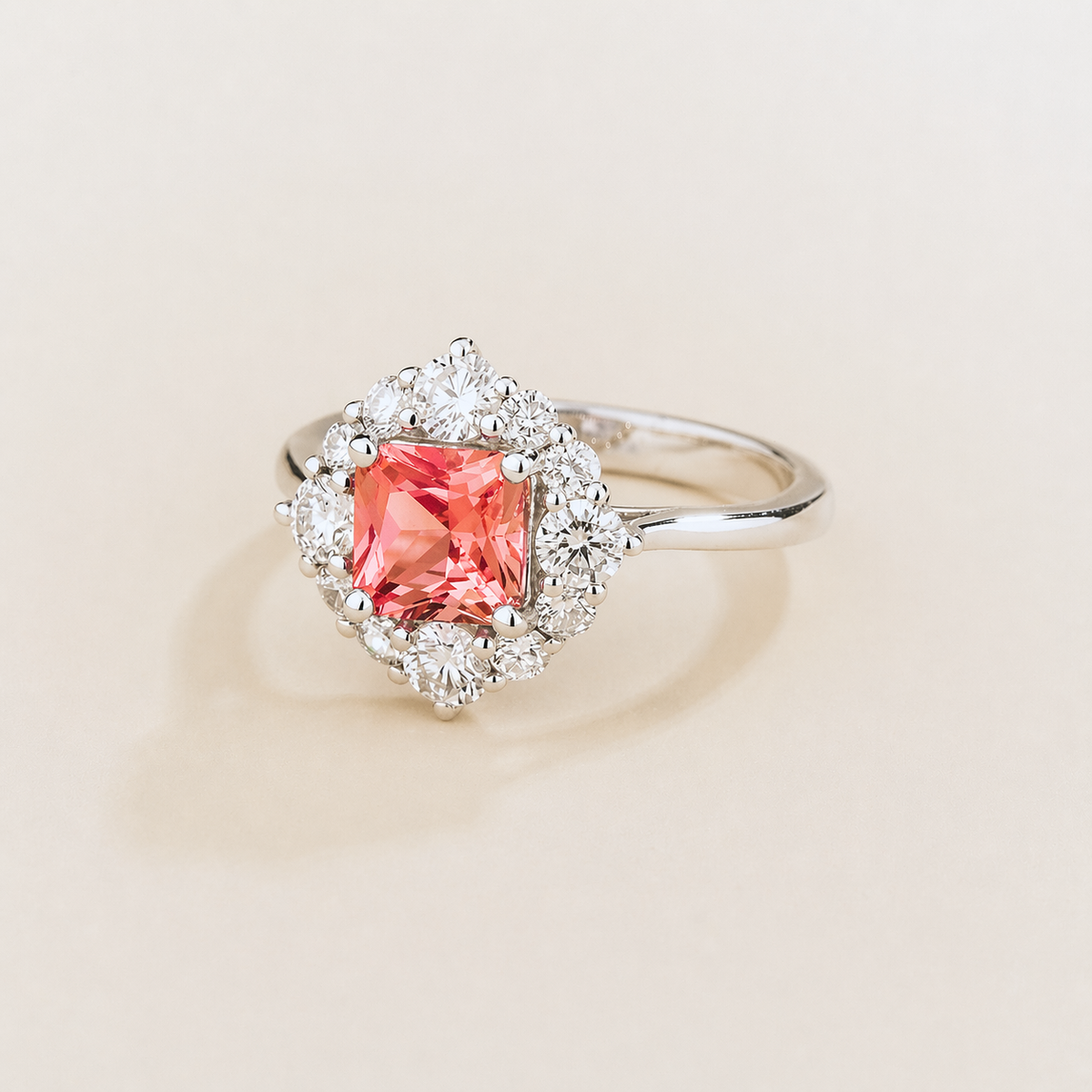 Tuli cushion-cut lab-grown Padparadscha Sapphire and diamond halo ring in white gold – angle view | Juvetti London