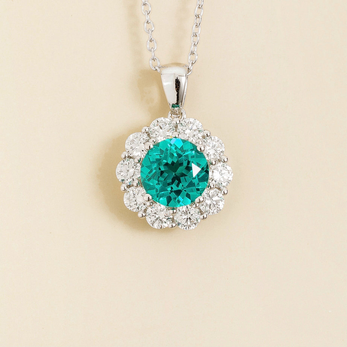 Floret round lab-grown paraiba sapphire and diamond halo pendant necklace in white gold – front | Juvetti London