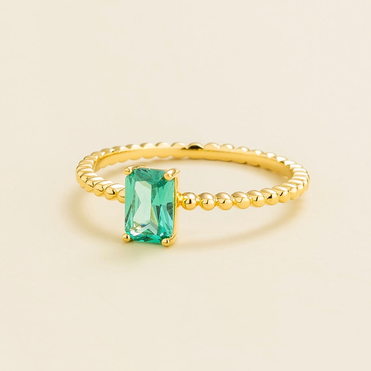 Fondi emerald-cut lab-grown Paraiba sapphire beaded band ring in gold – angle view | Juvetti London