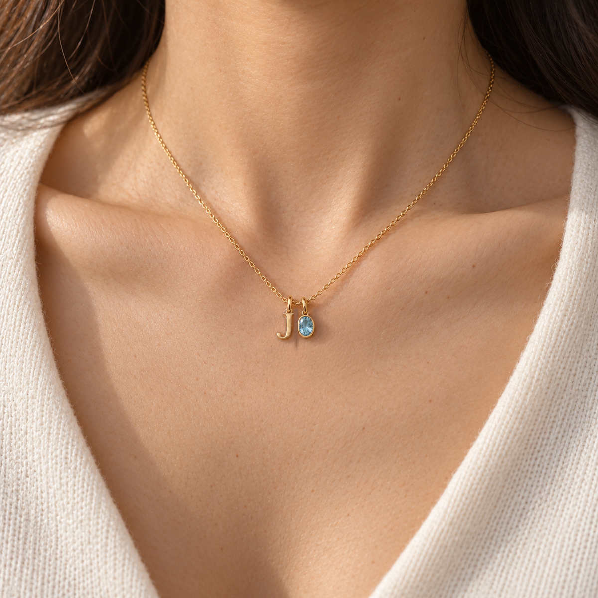 Personalised initial and gemstone charm necklace in gold worn on model, shown at true size