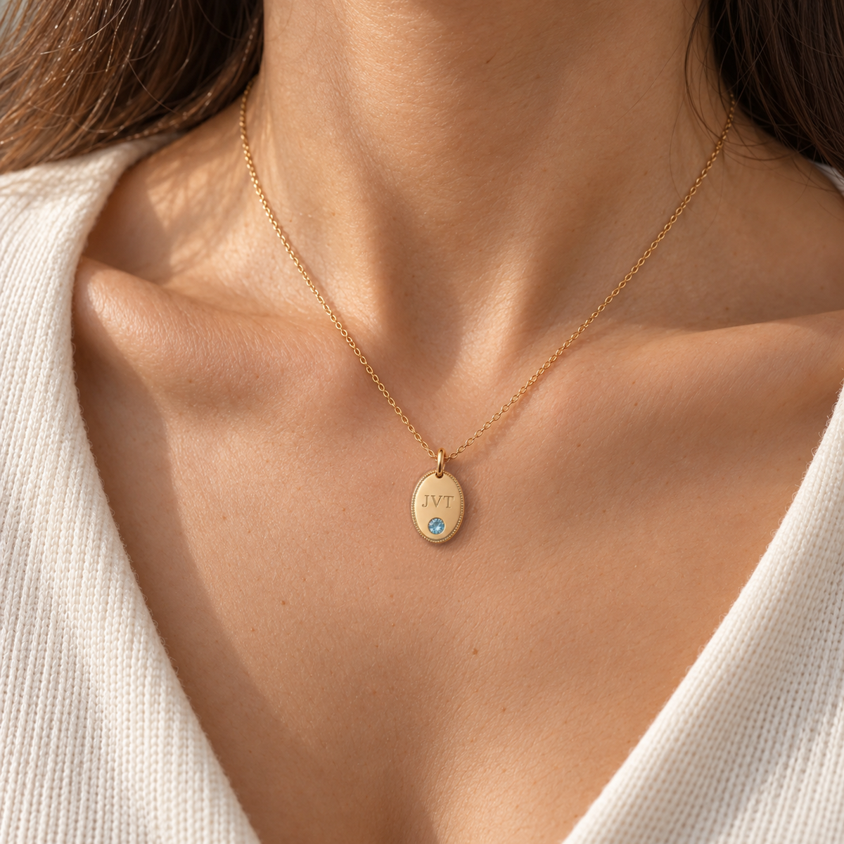 Personalised initial oval pendant necklace in gold worn on model, shown at true size