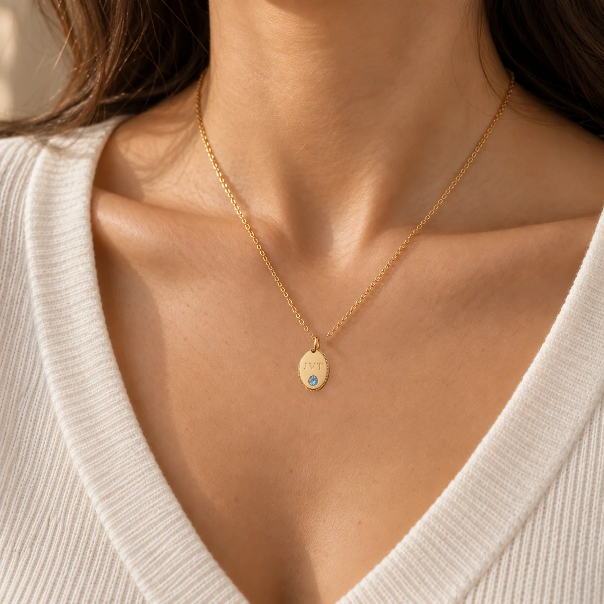Personalised initial oval pendant necklace in gold worn on model, shown at true size