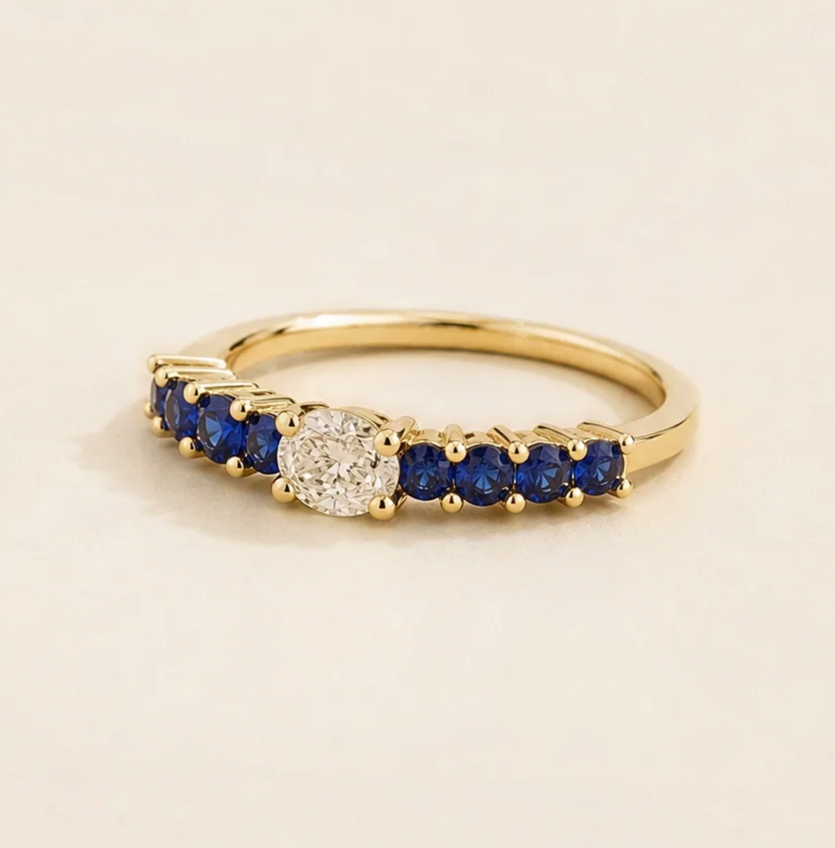 Petra Oval Diamond and Blue Sapphire Half Eternity Ring in Gold Angle view