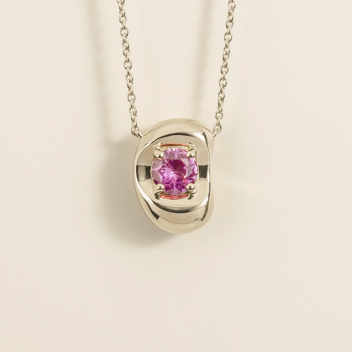 Fava round lab-grown pink sapphire pendant necklace in white gold, sculpted pebble setting, front view | Juvetti London