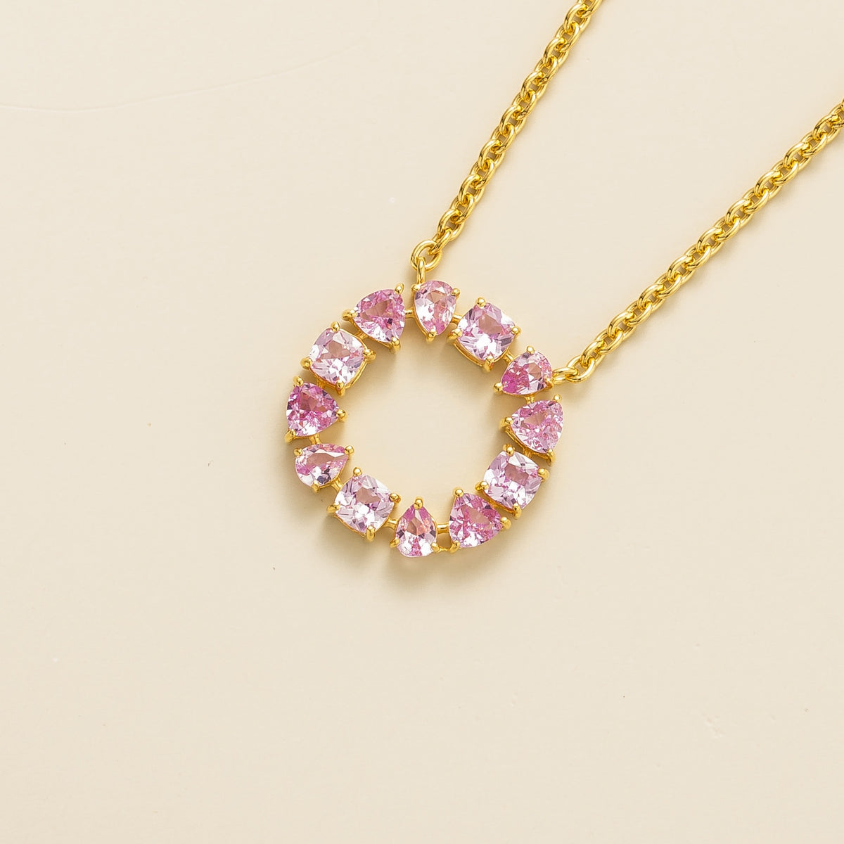 Glorie pink sapphire open circle pendant necklace in gold, mixed-cut lab-grown sapphires, angled view | Juvetti London
