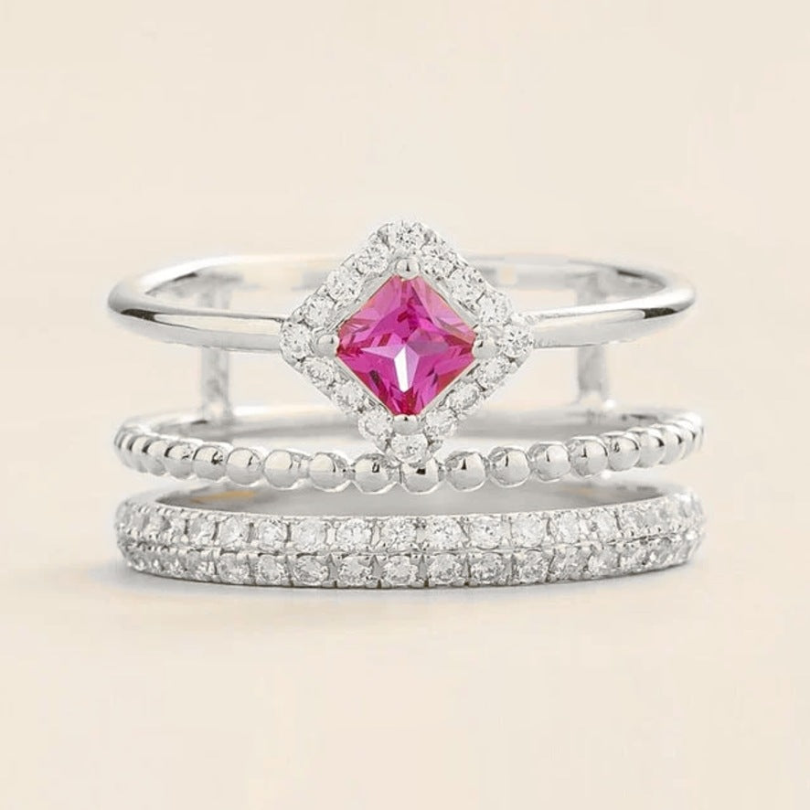 Amici triple-band stacking ring in white gold, princess-cut lab-grown pink sapphire in a diamond halo with beaded and pavé bands, front view | Juvetti London