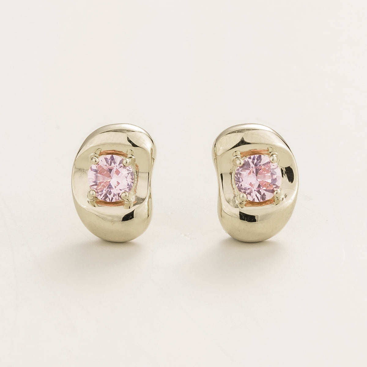 Fava round lab-grown pink sapphire stud earrings in white gold, sculpted pebble setting, front view | Juvetti London