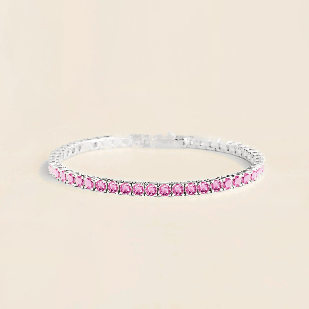 A white gold tennis bracelet set with round pink sapphire gemstones.