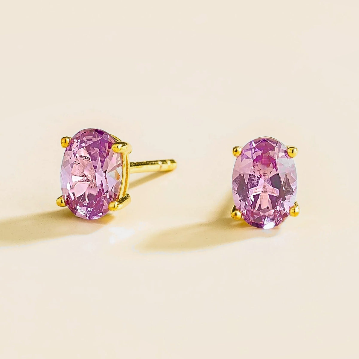 Oval purple sapphire solitaire stud earrings set in gold