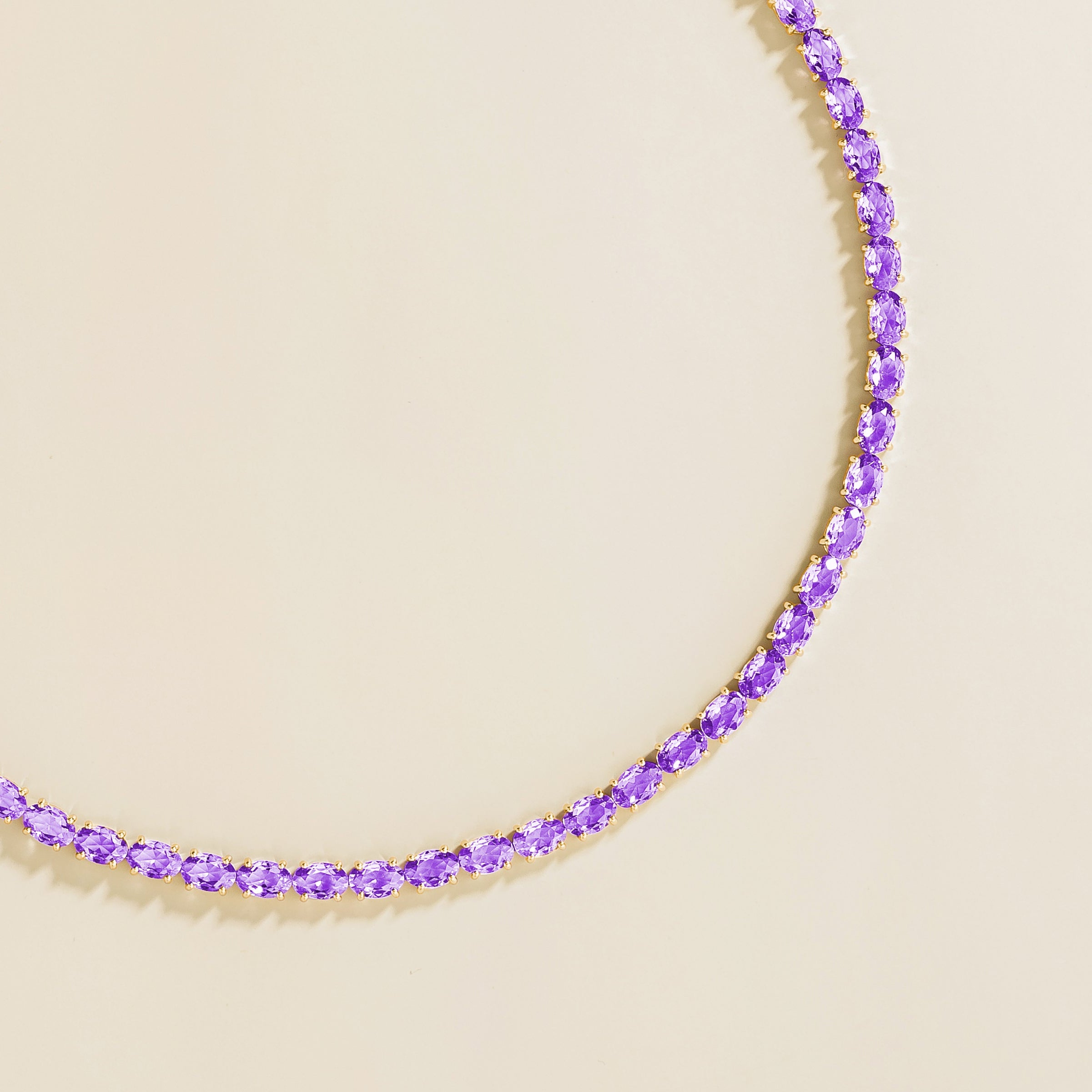 Side view of the oval purple sapphire on the Salto necklace in gold, Juvetti jewellery