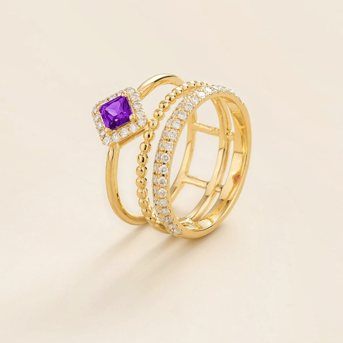 Amici triple-band stacking ring in gold, princess-cut lab-grown purple sapphire in a diamond halo with beaded and pavé bands, side view | Juvetti London