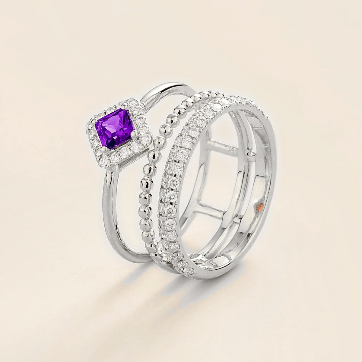 Amici triple-band stacking ring in white gold, princess-cut lab-grown purple sapphire in a diamond halo with beaded and pavé bands, side view | Juvetti London