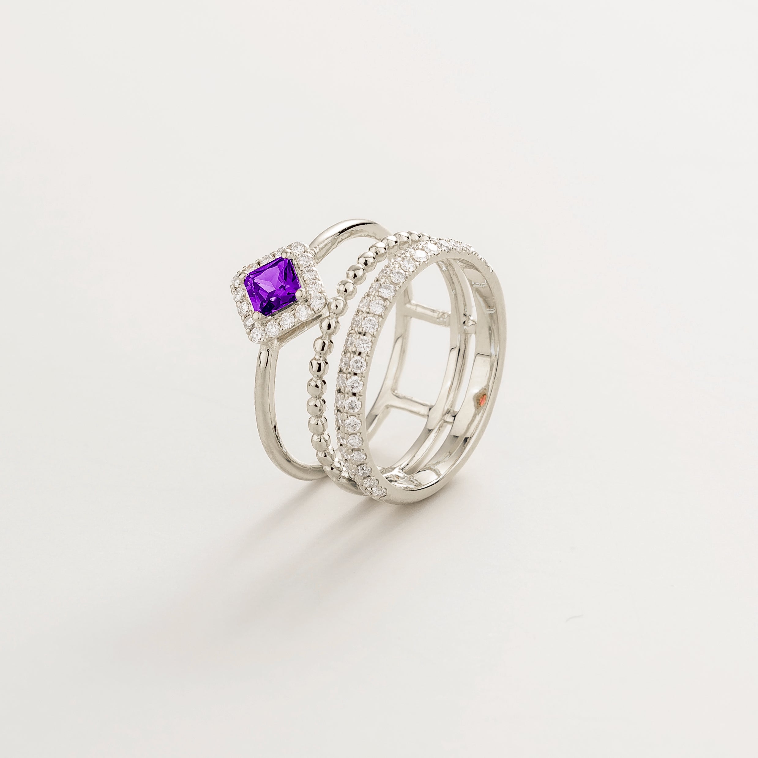 Angled view of the round purple sapphire on the Amici ring in white gold, Juvetti jewellery