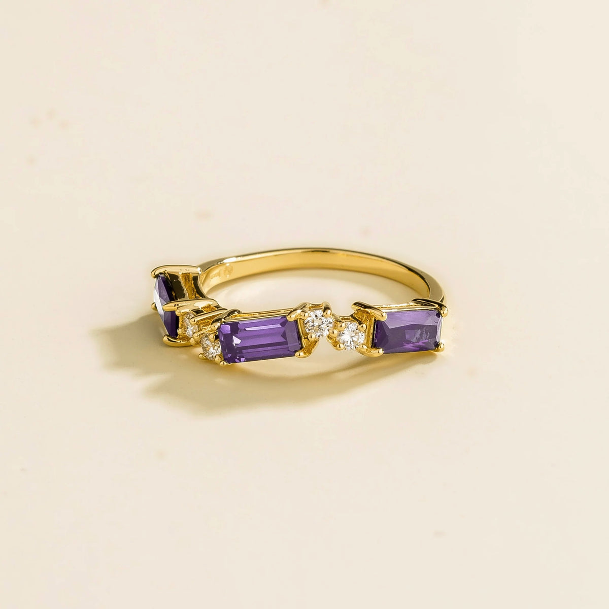 Side view of the Forma purple sapphire ring in gold showing the baguette purple sapphire, Juvetti London