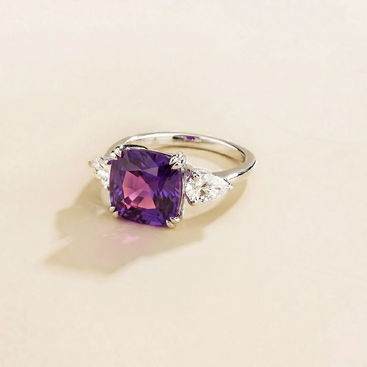 Side view of the Roue purple sapphire ring in white gold showing the cushion purple sapphire, Juvetti London