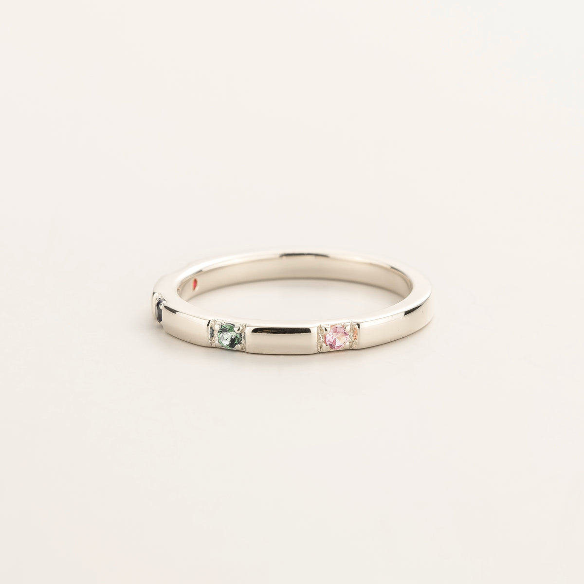 Balans Ruby, Blue Sapphire, Emerald & Pink Sapphire Station Band Ring in White Gold – angle view