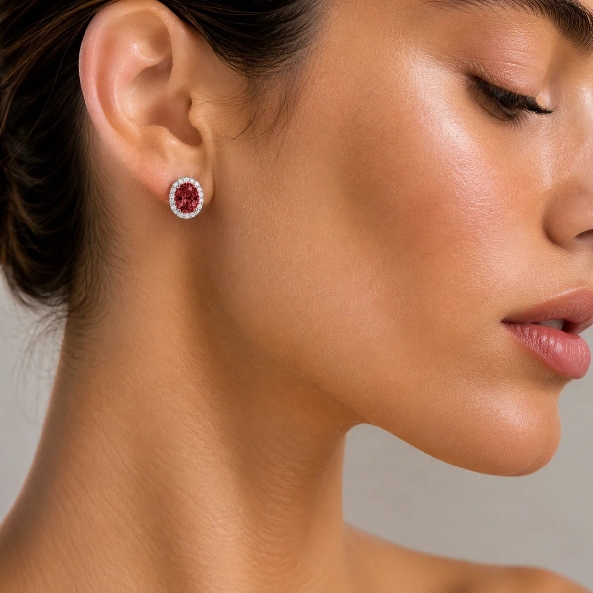 Model wearing lab-grown ruby and diamond oval halo stud earrings in white gold | Mina by Juvetti