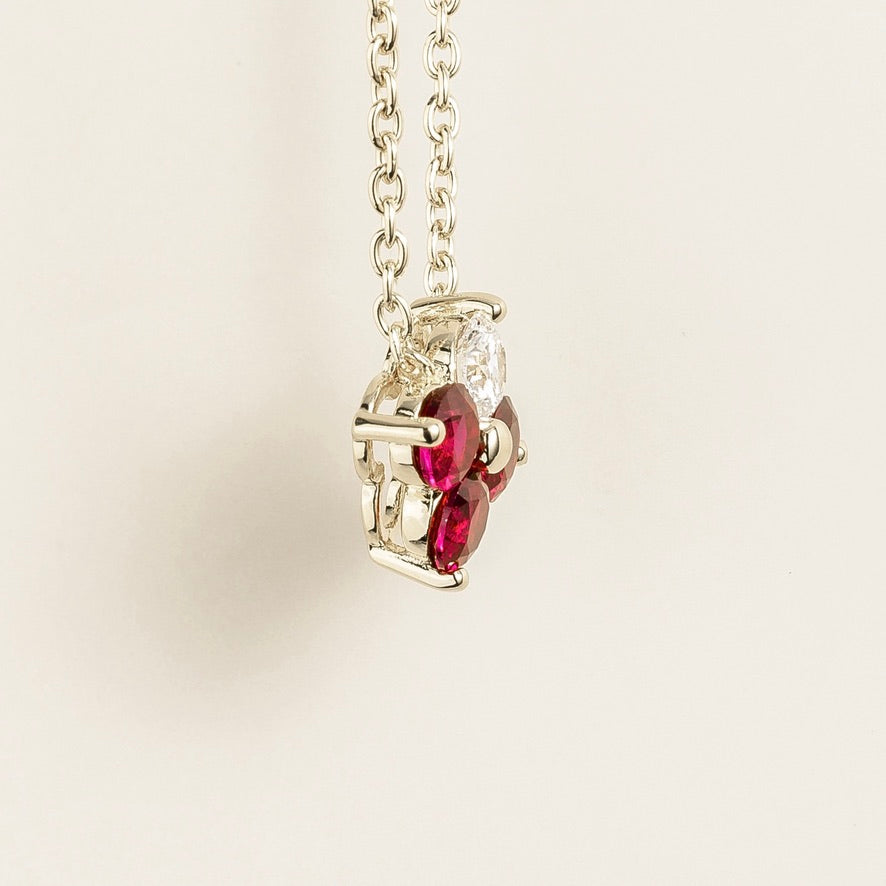 Angled view of the Clover ruby necklace in white gold showing the round ruby, Juvetti London