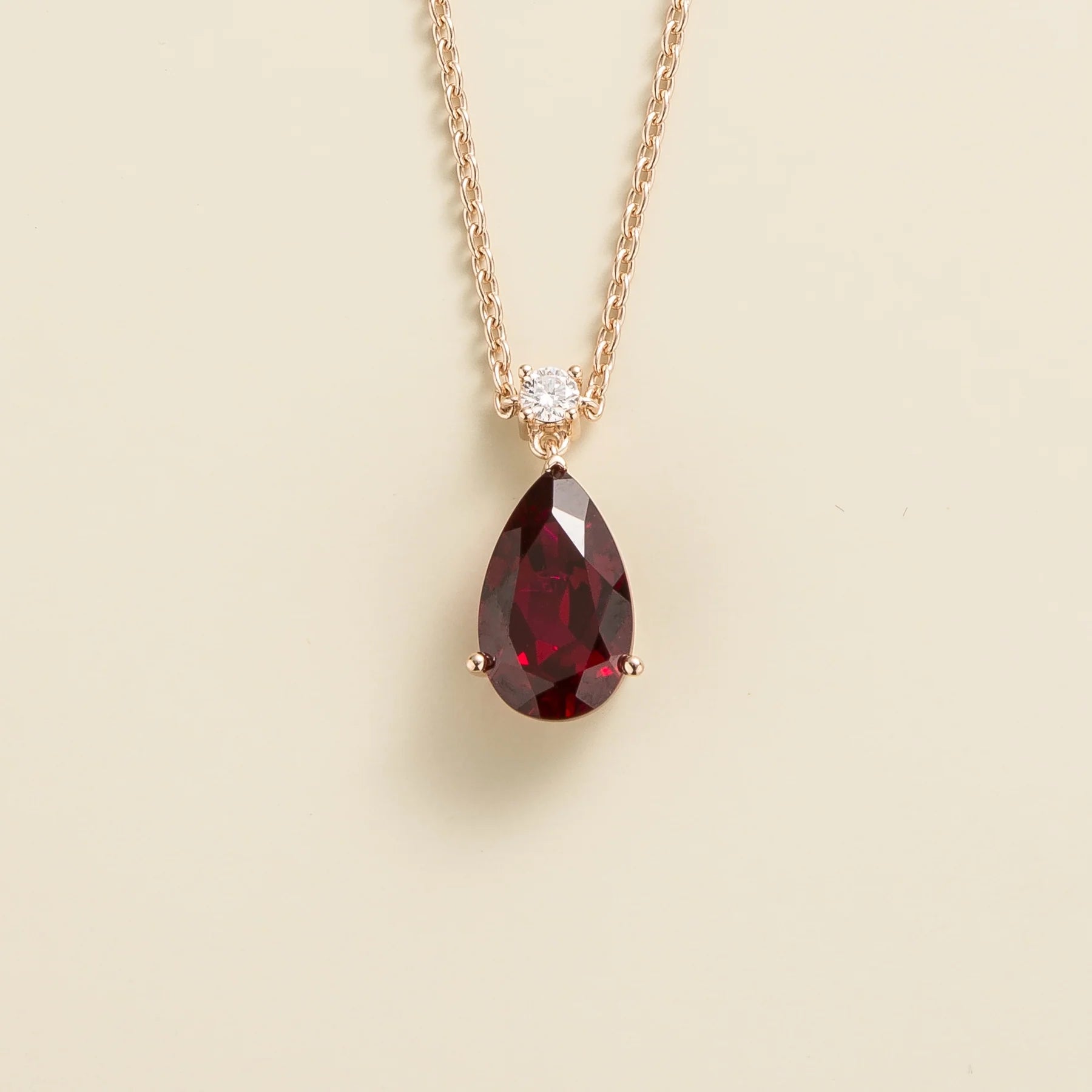 Angled view of the Pisa ruby necklace in rose gold showing the pear ruby, Juvetti London