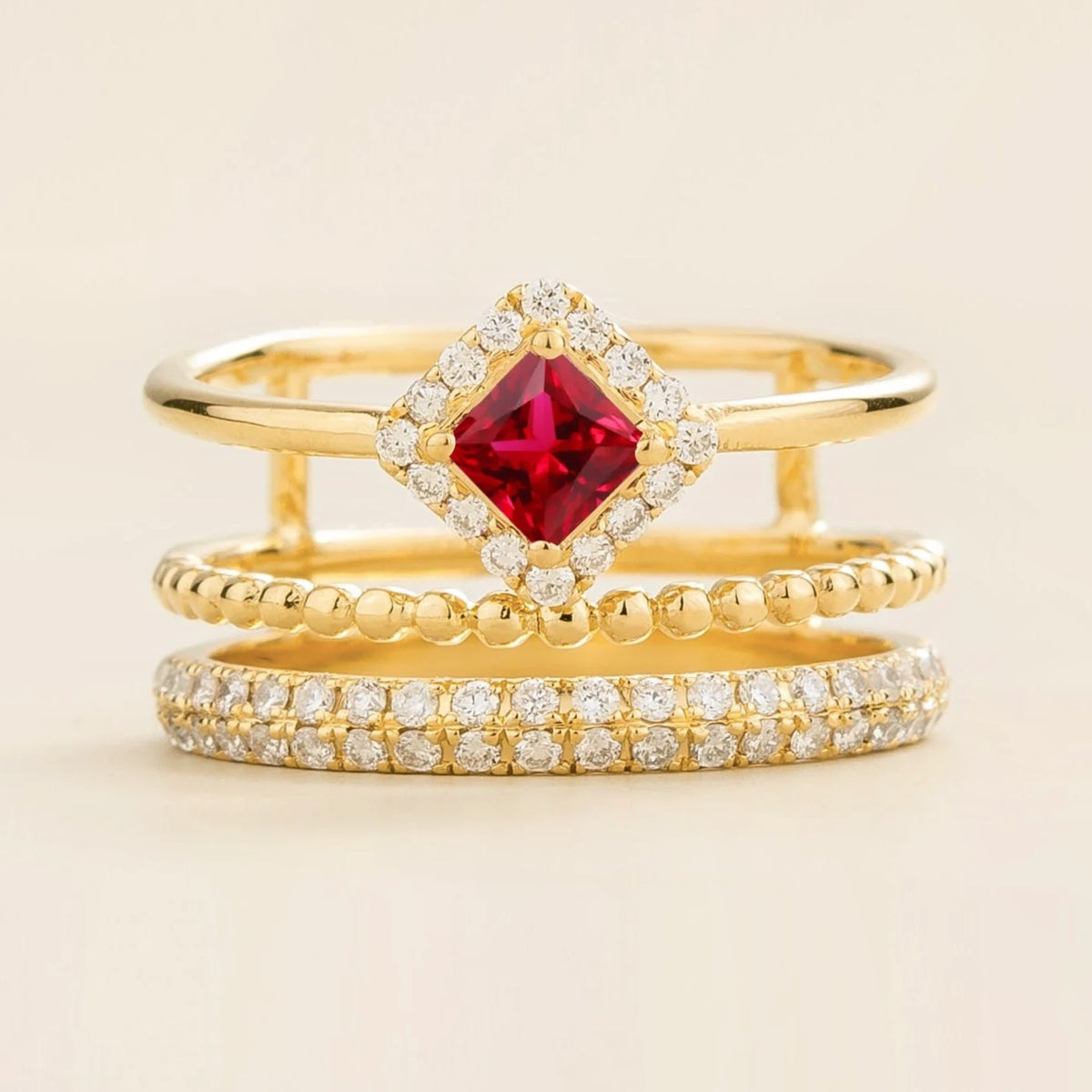 Amici triple-band stacking ring in gold, princess-cut lab-grown ruby in a diamond halo with beaded and pavé bands, front view | Juvetti London