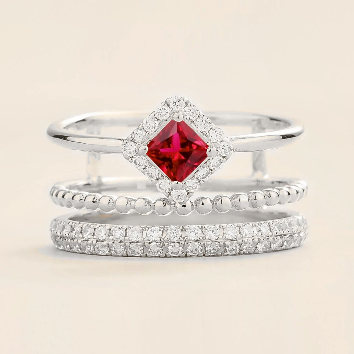 Amici triple-band stacking ring in white gold, princess-cut lab-grown ruby in a diamond halo with beaded and pavé bands, front view | Juvetti London