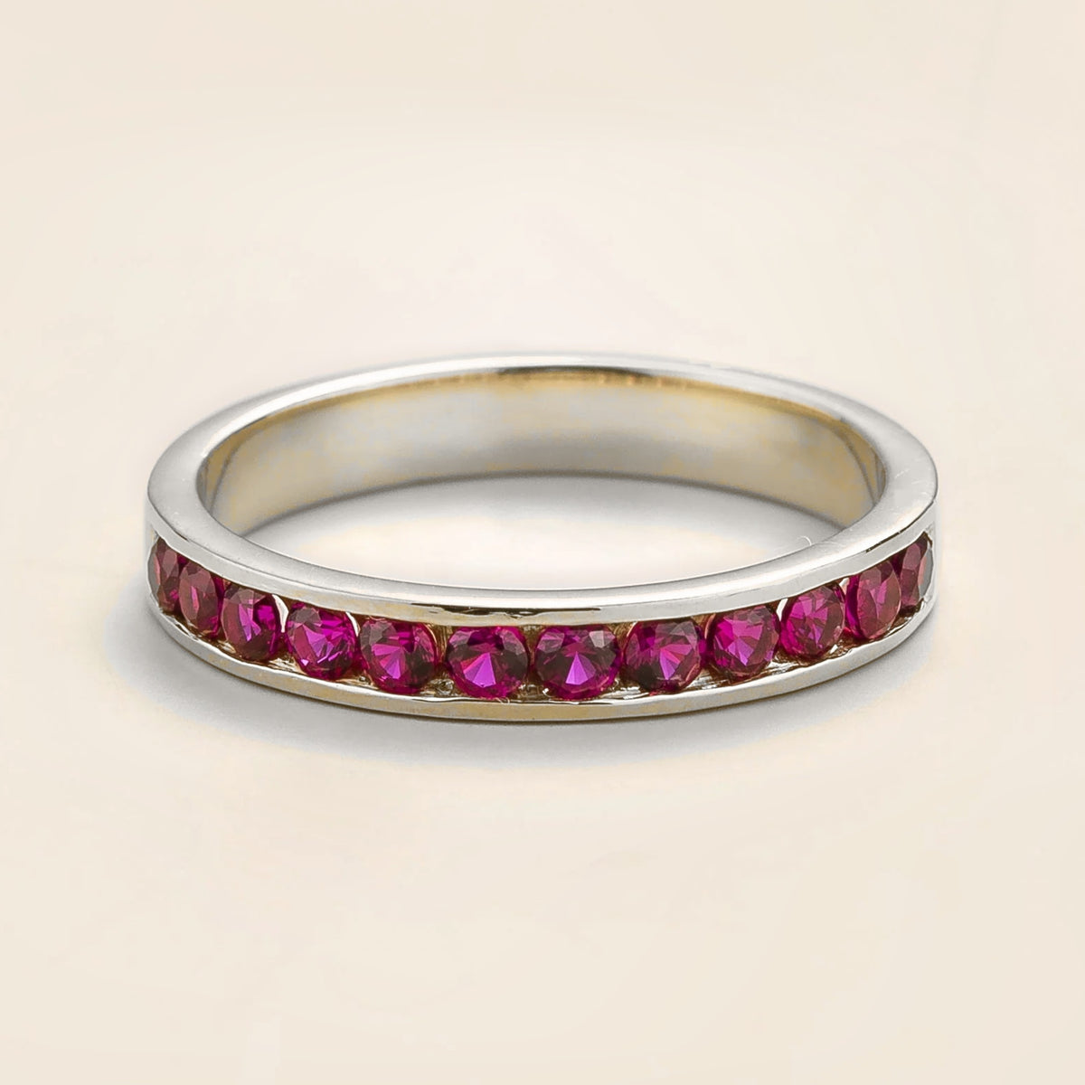 Juvetti white gold channel-set band featuring round lab-grown ruby gemstones.