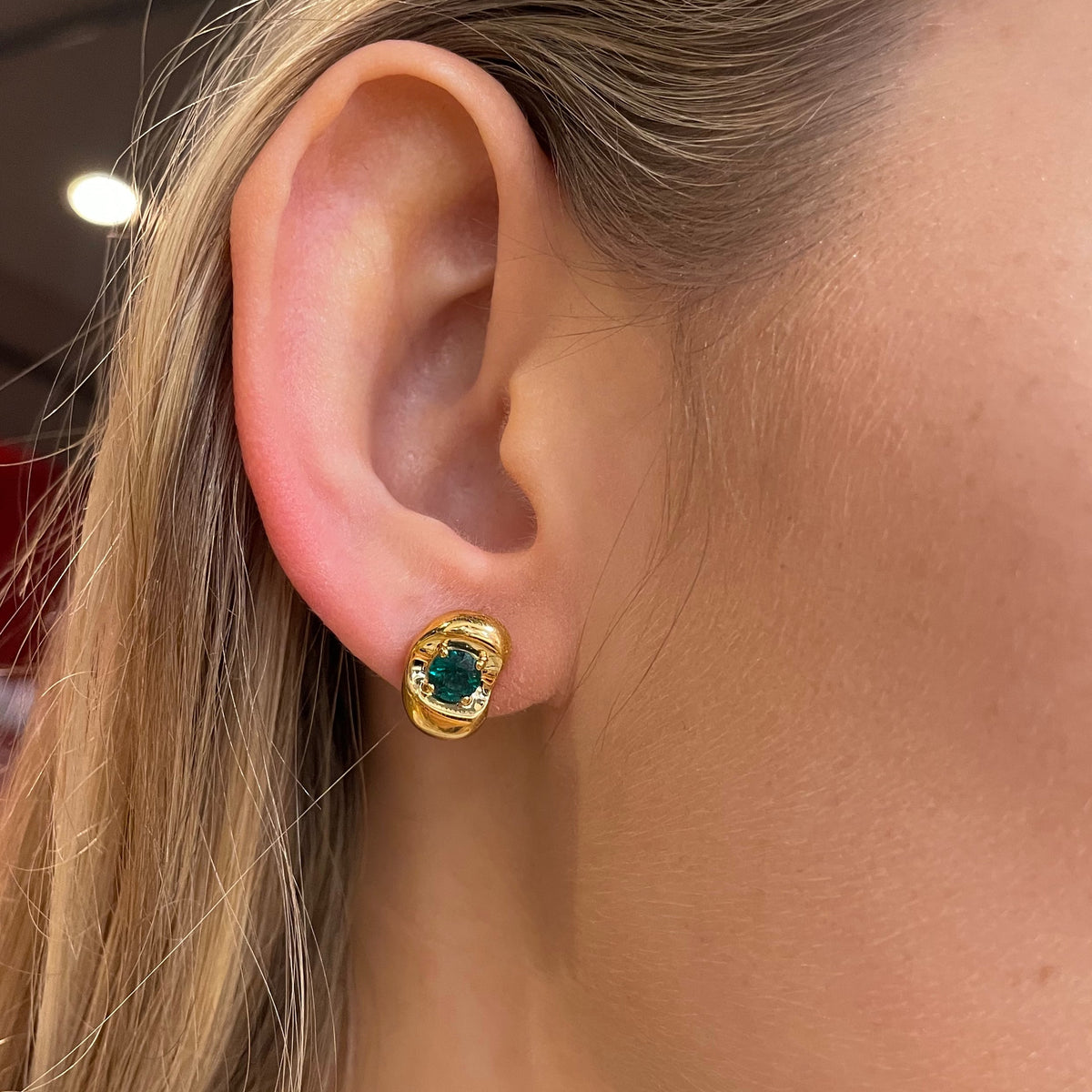 Fava round lab-grown ruby stud earrings in white gold, sculpted pebble setting, worn on the ear | Juvetti London