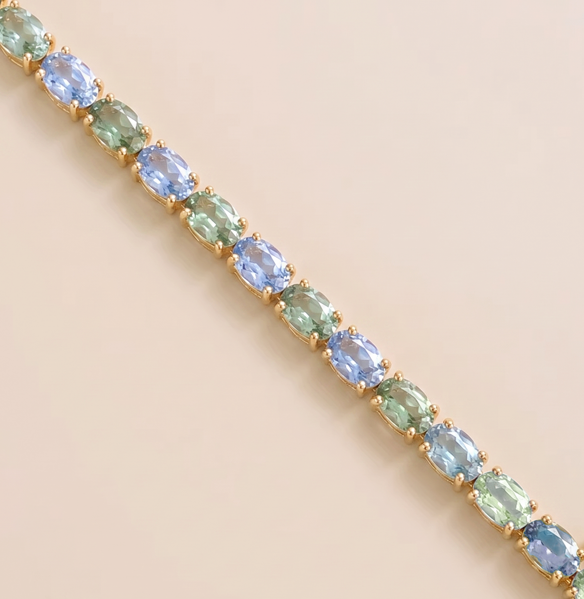 Oval lab-grown pastel blue and green sapphire tennis bracelet in gold | Juvetti London.
