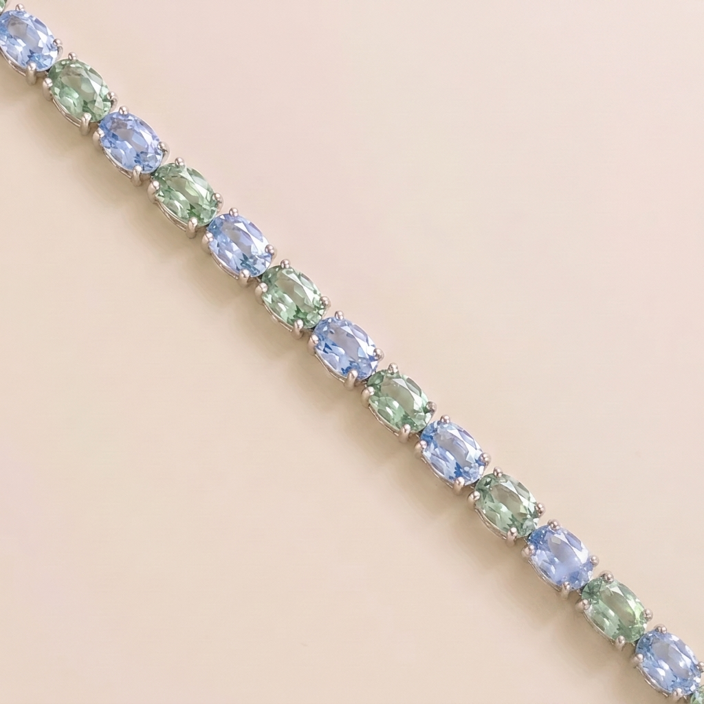 Oval lab-grown pastel blue and green sapphire tennis bracelet in white gold | Juvetti London.