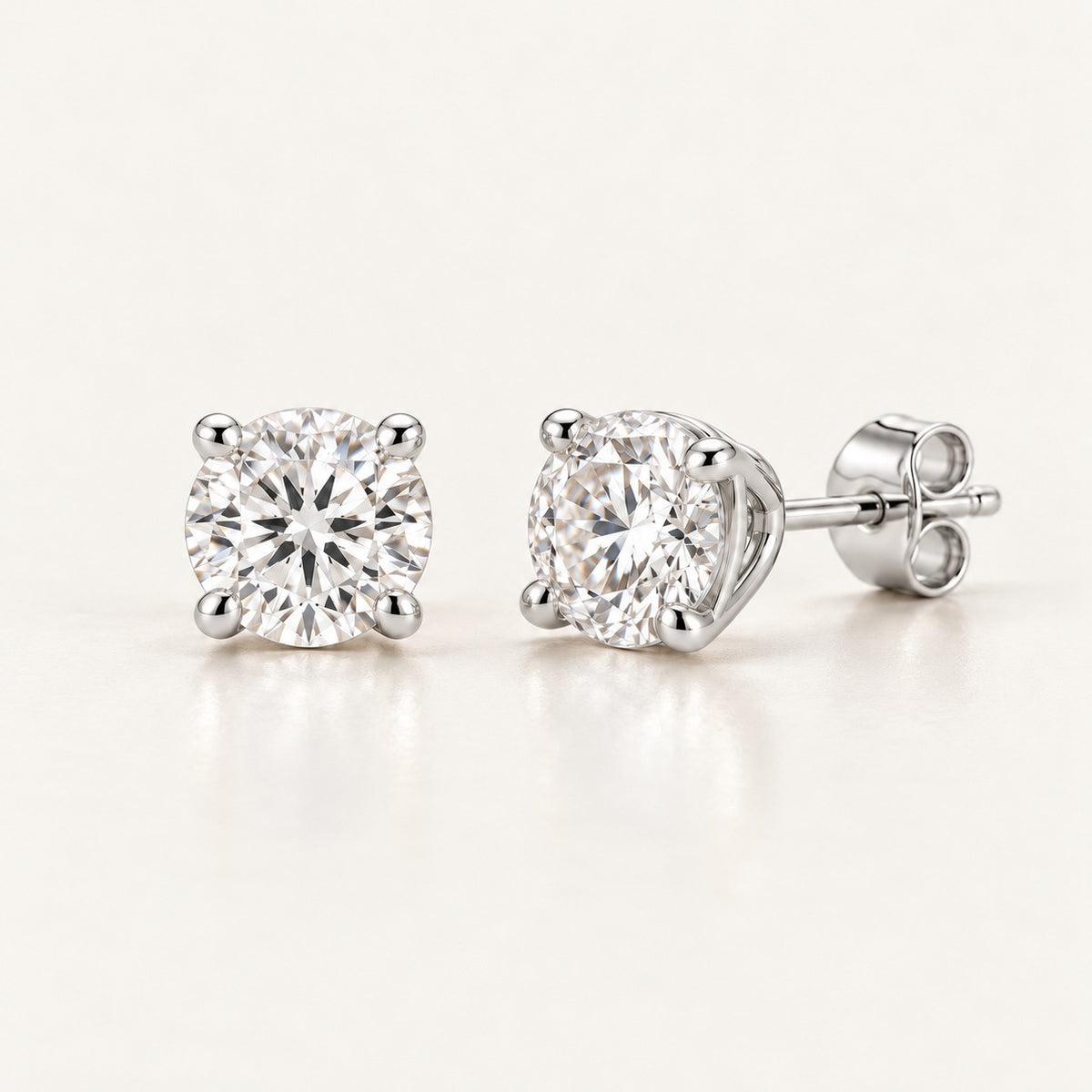 Pair of solitaire stud earring settings in white gold or platinum, shown with 1 ct round diamonds