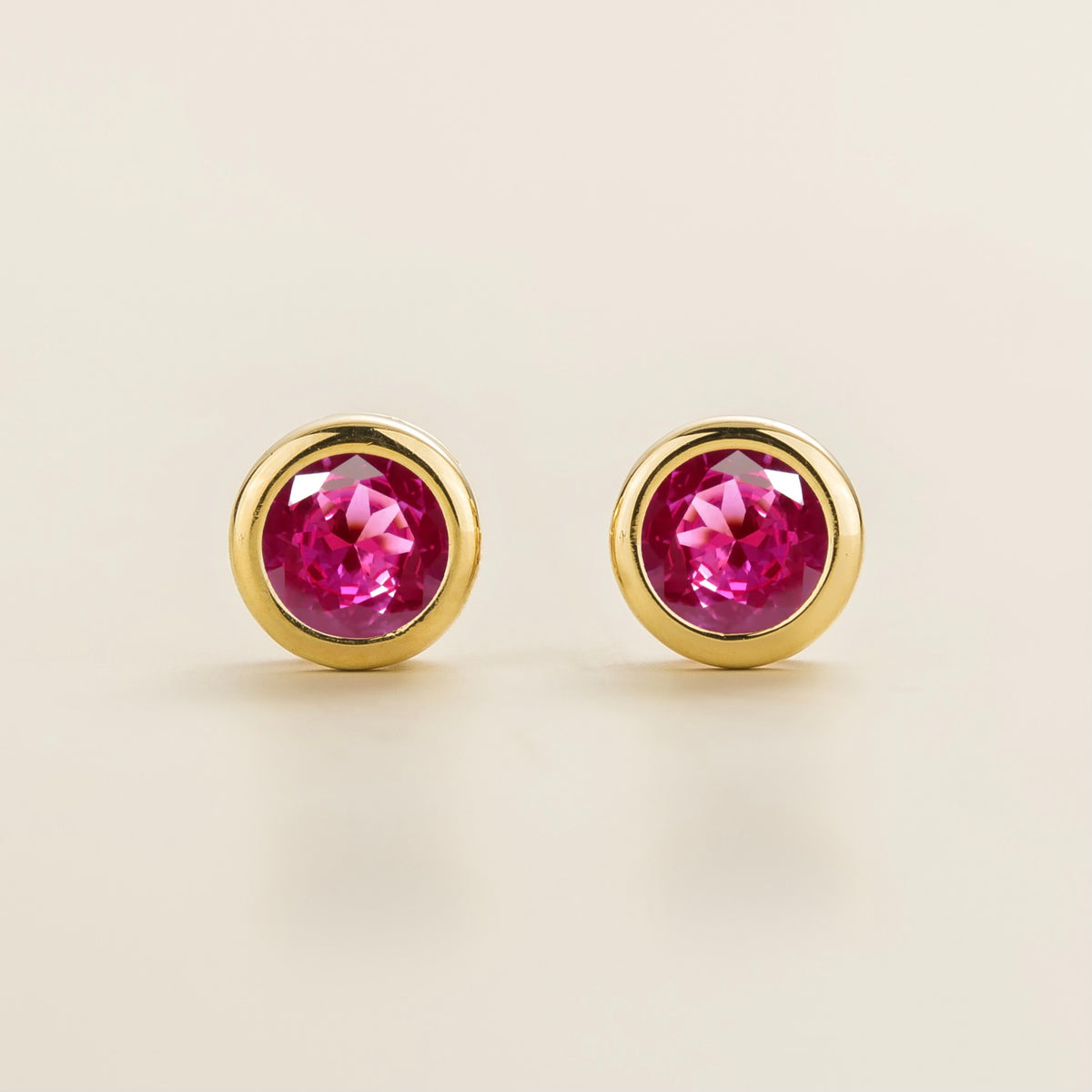 Margo vivid pink sapphire round bezel set solitaire stud earrings in gold