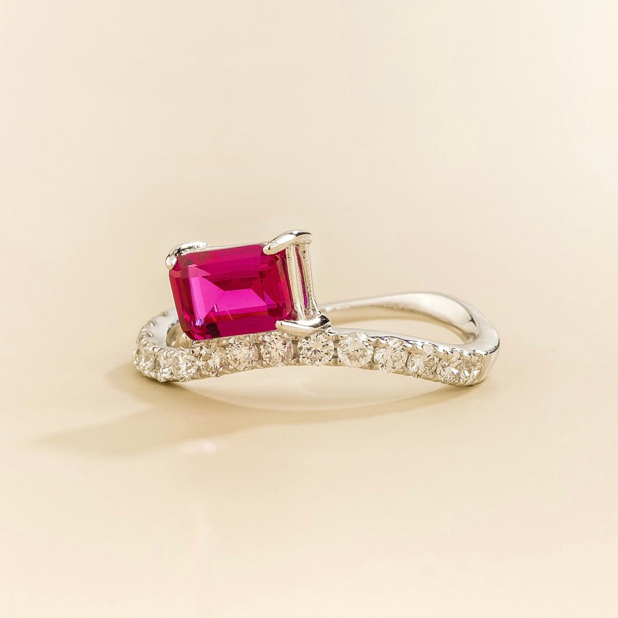 Luno vivid pink sapphire emerald-cut ring with diamond pavé in white gold, lab-grown sapphire set east-west, angled view | Juvetti London