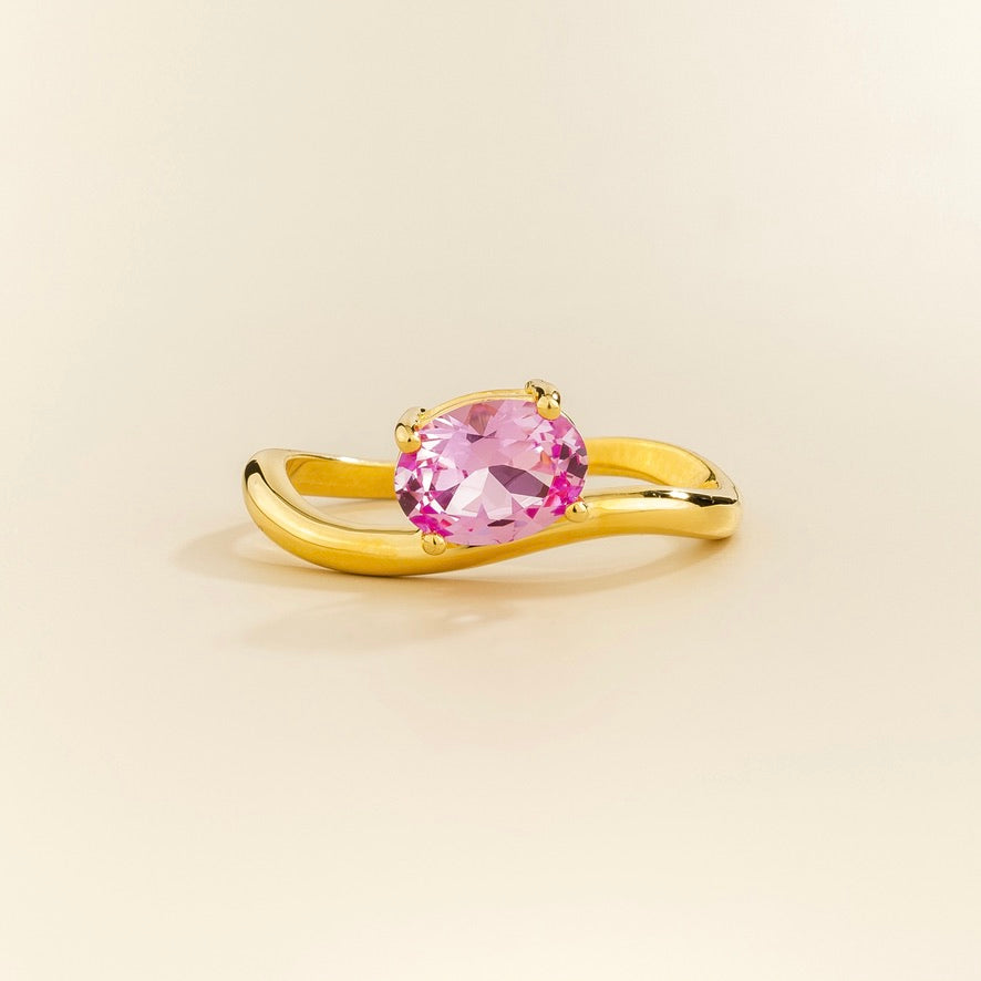 Luno vivid pink sapphire oval ring in gold, lab-grown sapphire set east-west, side view | Juvetti London
