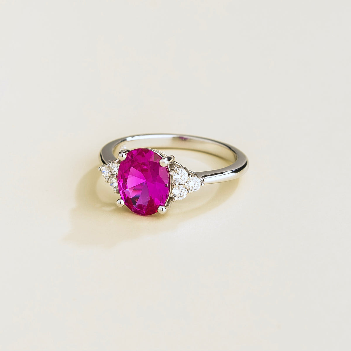 Ovo Vivid Pink Sapphire Oval Solitaire Ring with Diamond Shoulders in White Gold – angle view