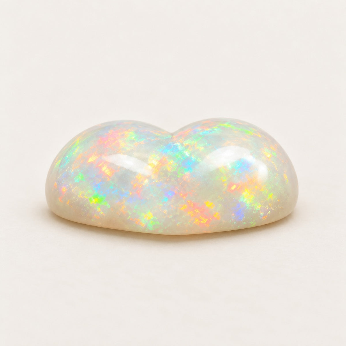 White lab-grown opal, heart cabochon, side view
