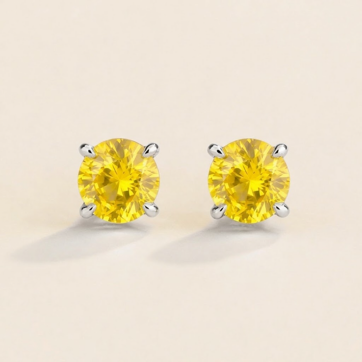 Nina round lab-grown yellow sapphire solitaire stud earrings in white gold – front view | Juvetti London