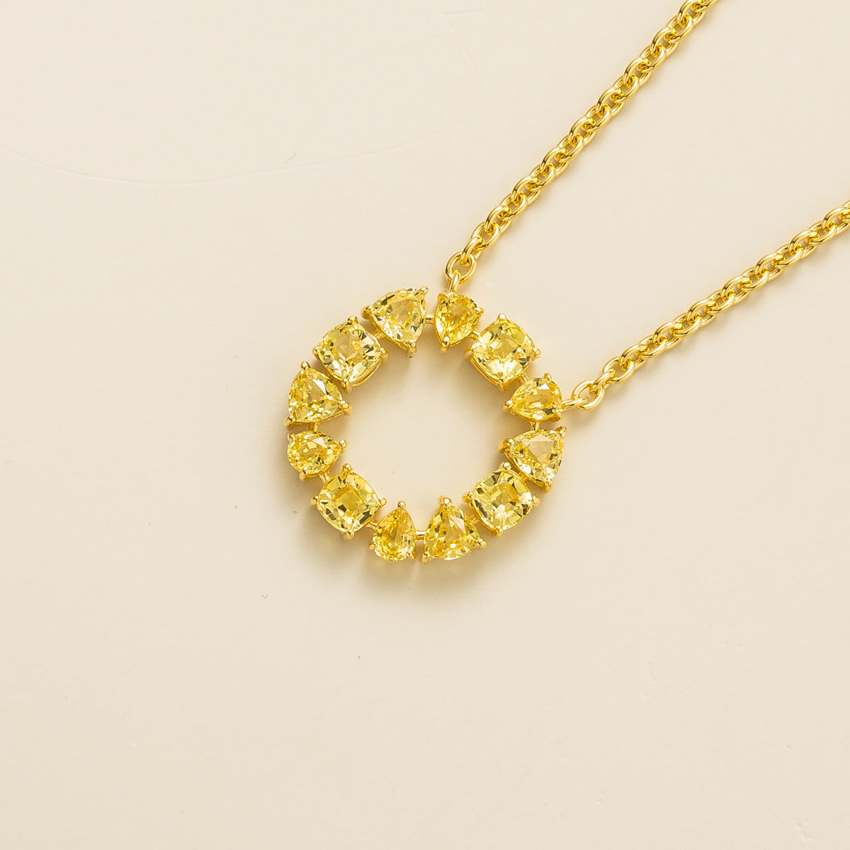 Glorie yellow sapphire open circle pendant necklace in gold, mixed-cut lab-grown sapphires, angled view | Juvetti London