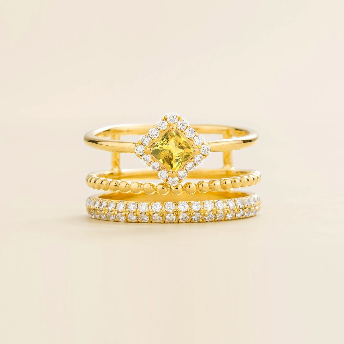 Amici triple-band stacking ring in gold, princess-cut lab-grown yellow sapphire in a diamond halo with beaded and pavé bands, front view | Juvetti London