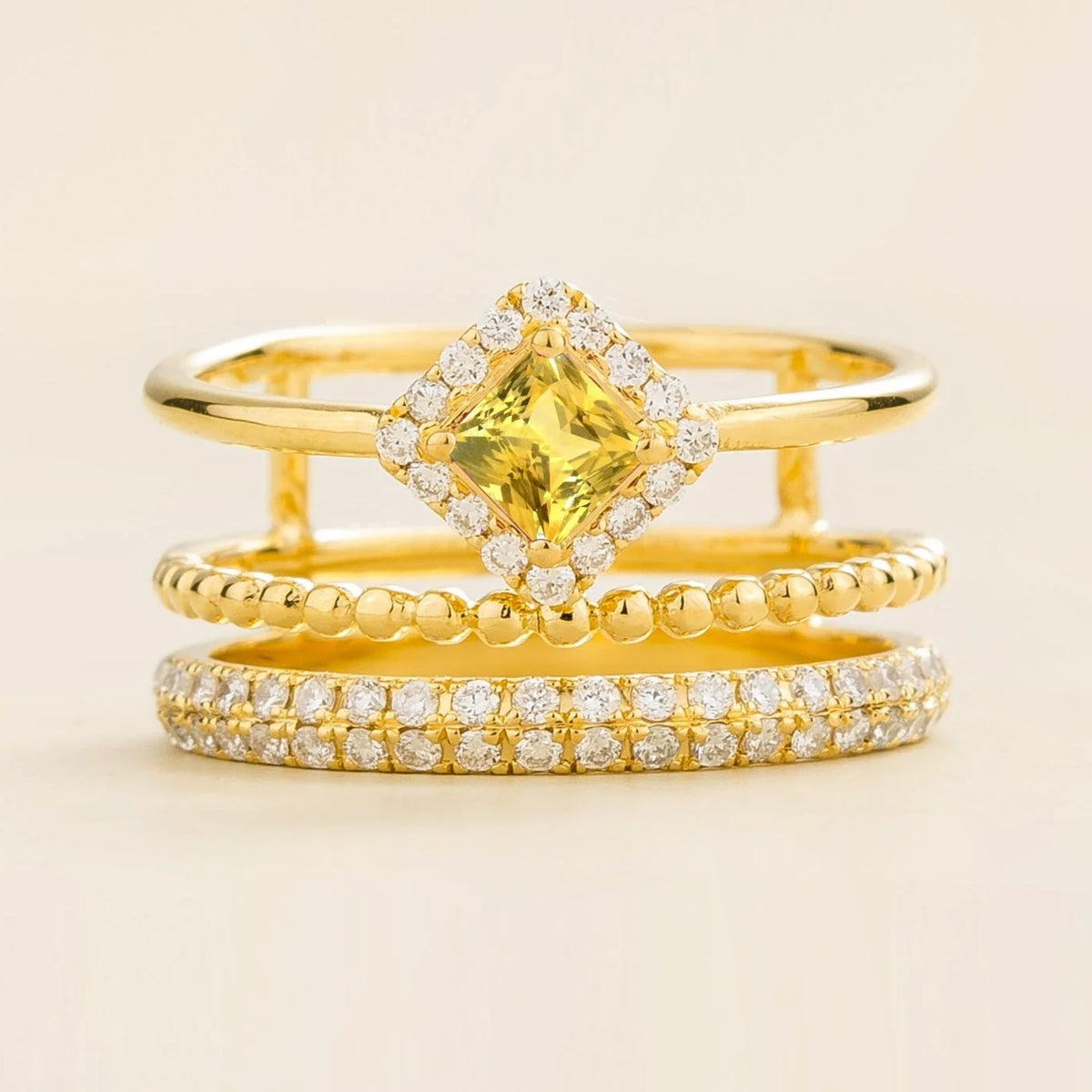 Amici triple-band stacking ring in gold, princess-cut lab-grown yellow sapphire in a diamond halo with beaded and pavé bands, front view | Juvetti London