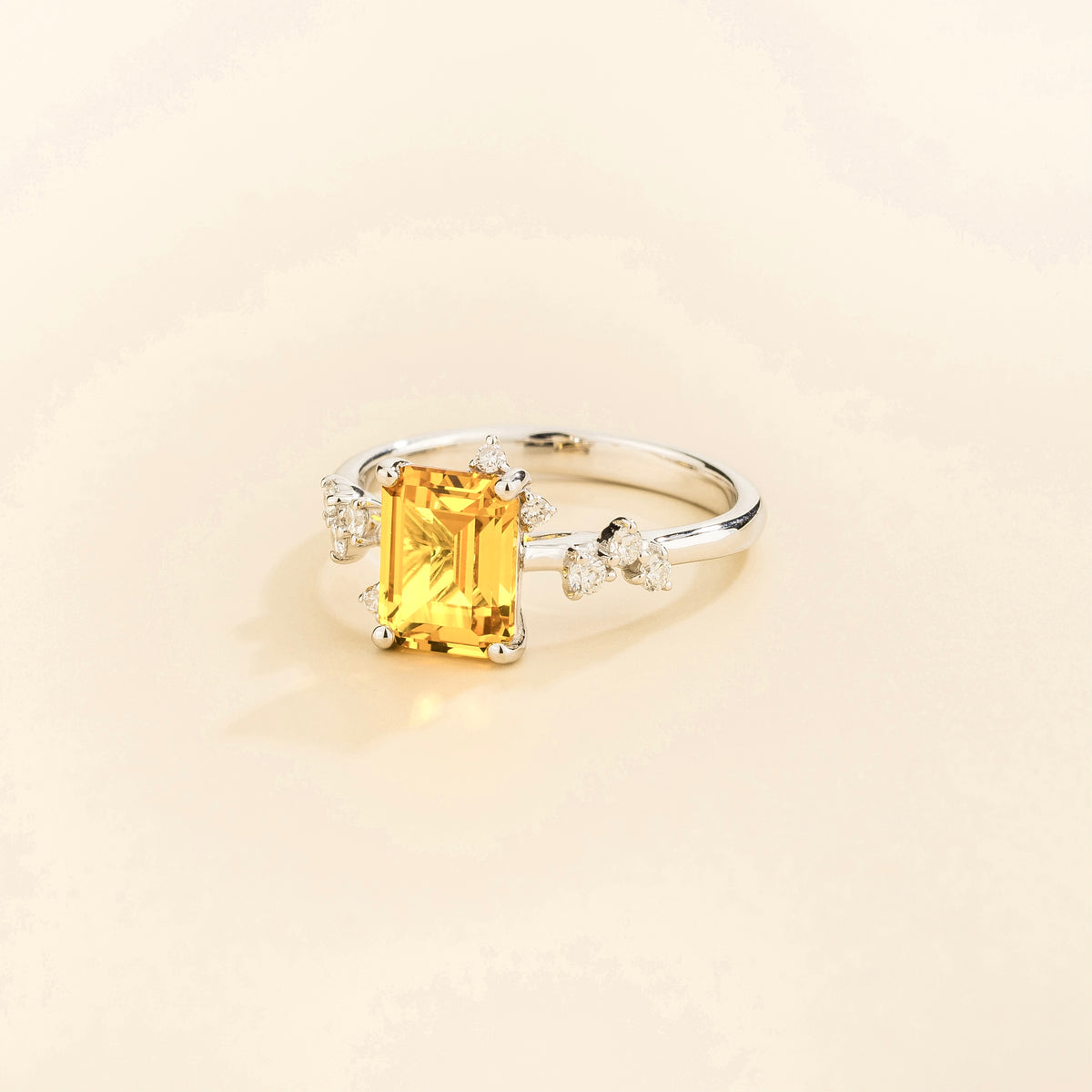 Frost emerald-cut yellow sapphire and diamond ring in white gold, lab-grown sapphire with scattered diamonds, angled view | Juvetti London