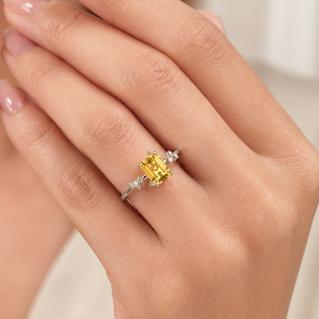 Frost emerald-cut yellow sapphire and diamond ring in white gold, lab-grown sapphire with scattered diamonds, worn on the hand | Juvetti London