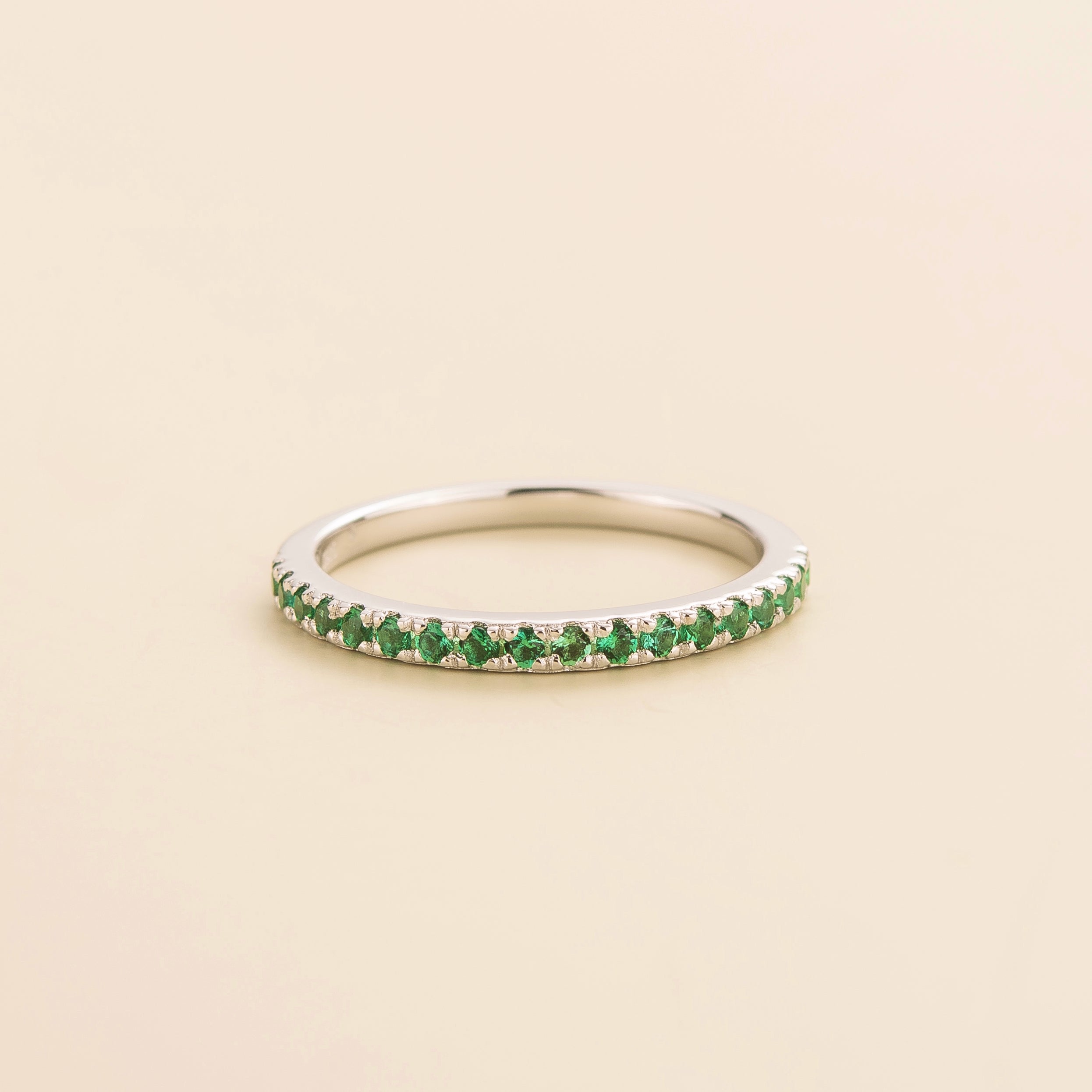 Juvetti white gold half eternity band set with round lab-grown emeralds.