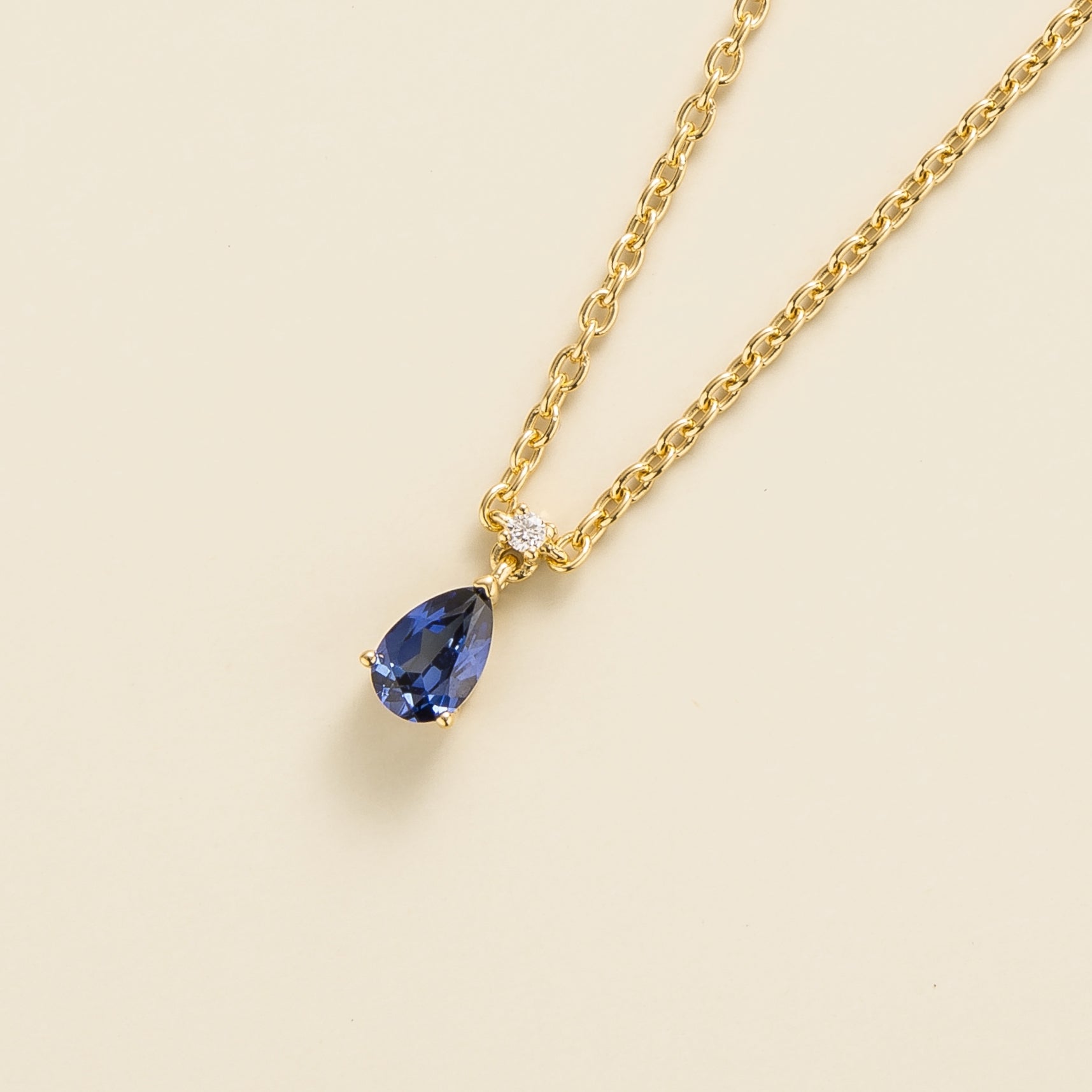delicate gold necklace with pear blue sapphire and diamond accent
