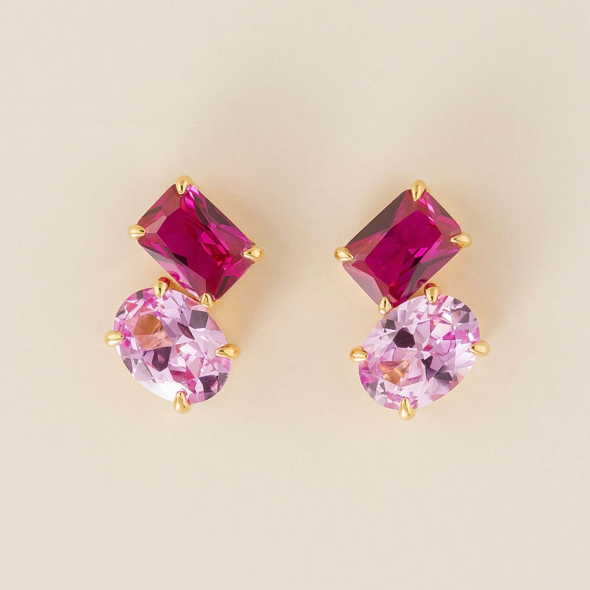 A pair of Toi et Moi gold earrings featuring emerald vivid pink sapphire cut and oval cut pastel pink sapphires. London jewellery store