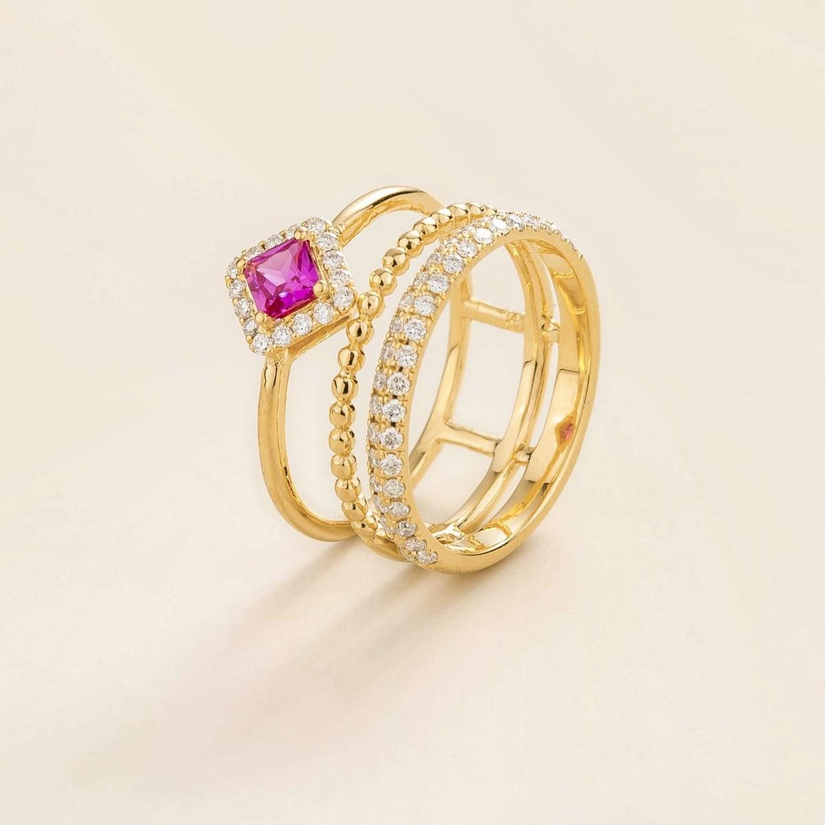 Amici triple-band stacking ring in gold, princess-cut lab-grown pink sapphire in a diamond halo with beaded and pavé bands, side view | Juvetti London