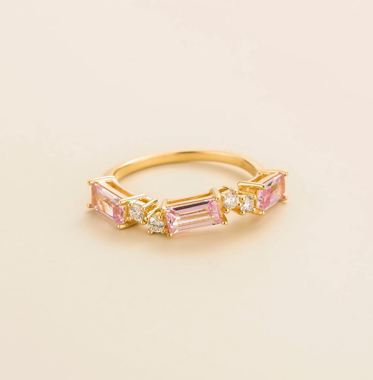 Juvetti gold ring showcasing ethical lab-grown baguette-cut pink sapphires and round brilliant diamonds.