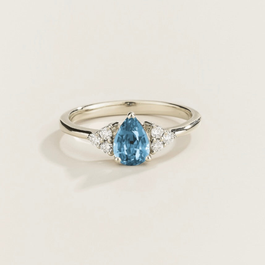 Juvetti white gold ring featuring a pear-cut lab-grown aquamarine with lab-grown diamond side stones.