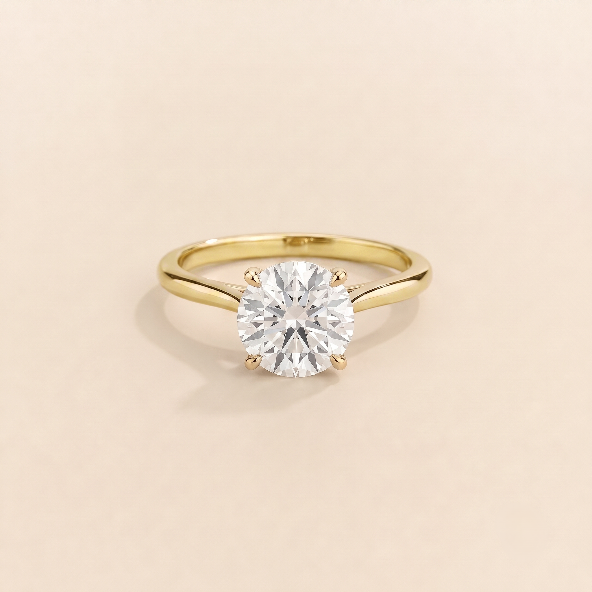 Kissen Ring in gold, set with a round cut Diamond in an east–west setting.