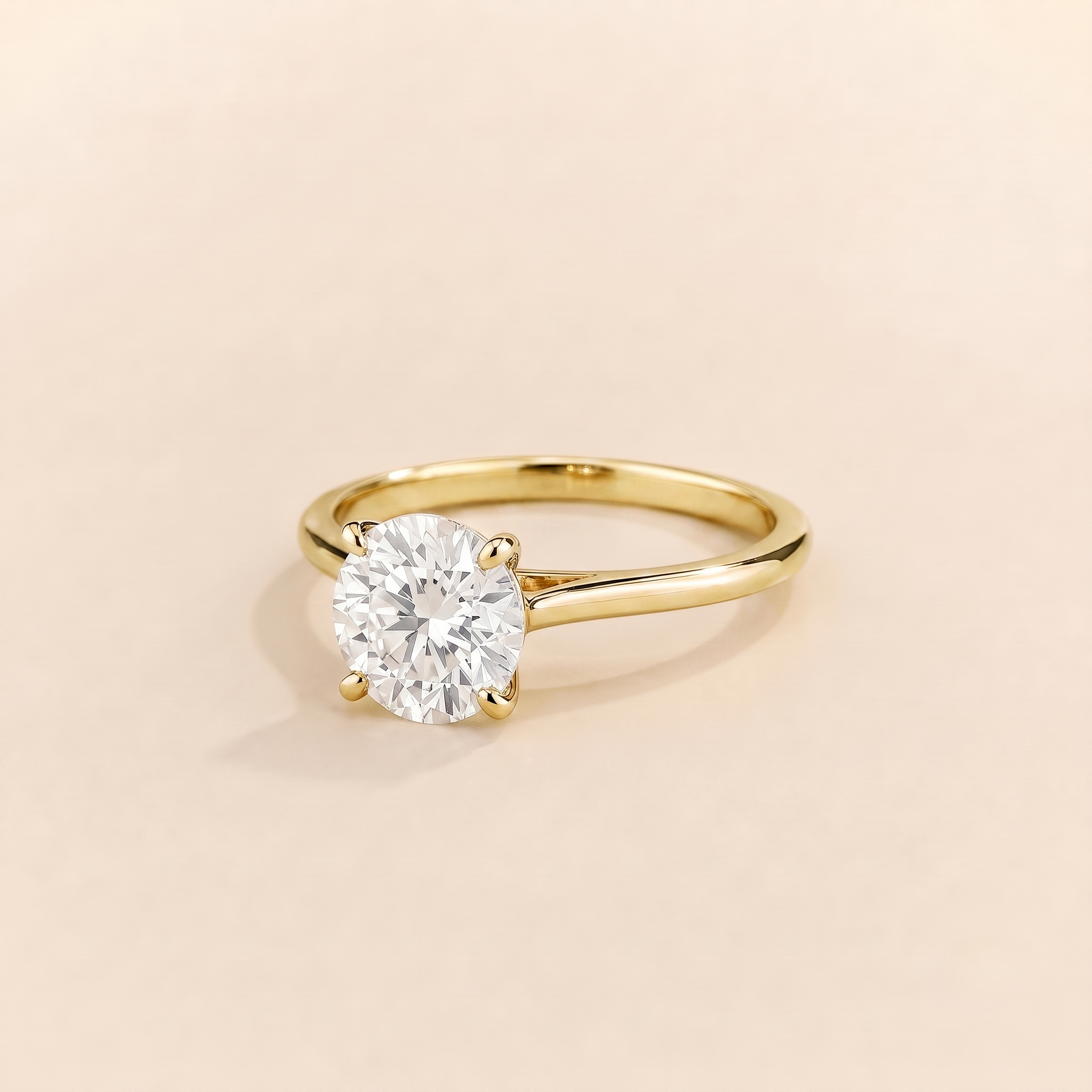Kissen Ring in gold, set with a round cut Diamond in an east–west setting.